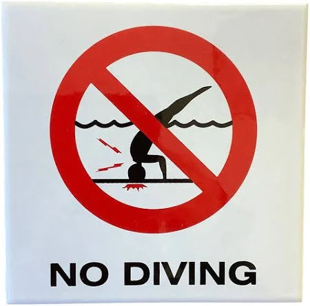 No Diving Symbol” message presented on one smooth ceramic tile on the swimming pool wall at the water line.